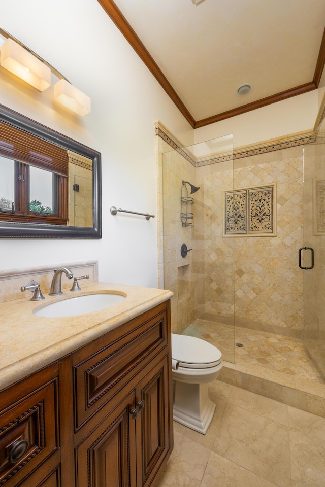 bathroom with vanity, crown molding, a shower with door, and toilet