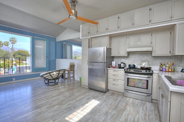 kitchen featuring tasteful backsplash, white cabinetry, appliances with stainless steel finishes, and light wood-type flooring