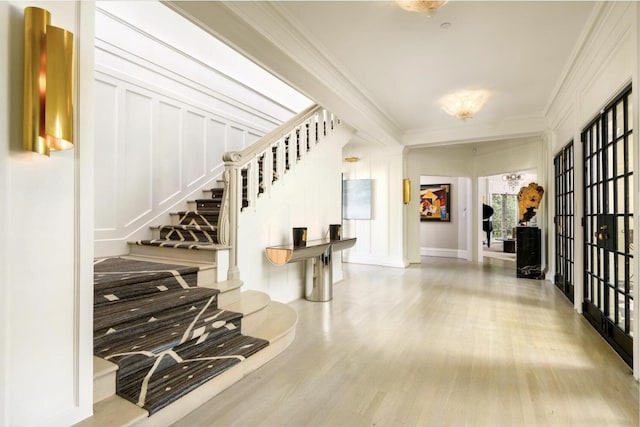 entrance foyer featuring crown molding and light wood-type flooring