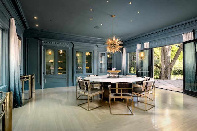 dining space featuring ornamental molding and light hardwood / wood-style floors