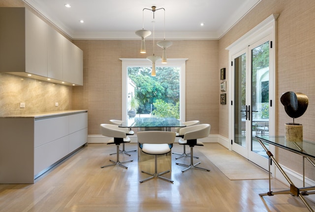 dining space featuring crown molding, french doors, and light parquet floors