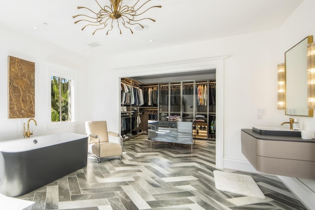 bathroom featuring vanity, a tub, and parquet floors