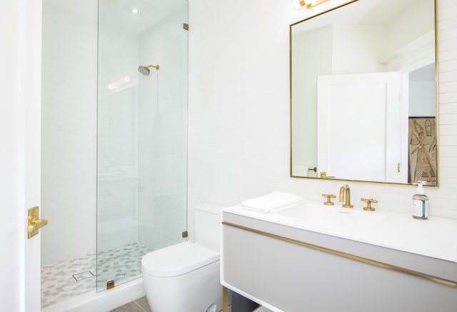 bathroom featuring vanity, toilet, and tiled shower