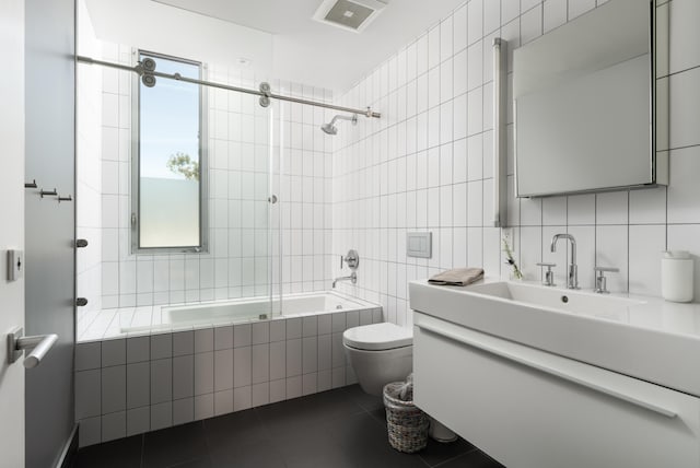 full bathroom with tile walls, vanity, tasteful backsplash, tiled shower / bath, and toilet