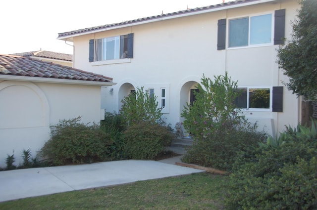 mediterranean / spanish-style home featuring a tiled roof and stucco siding