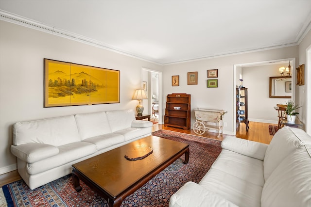 living room featuring hardwood / wood-style flooring, crown molding, and a chandelier