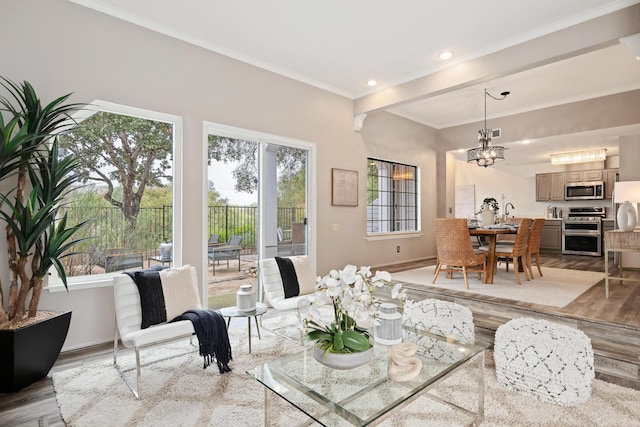 dining space with an inviting chandelier, crown molding, and light wood-type flooring