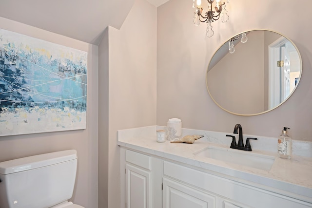 bathroom with vanity, a notable chandelier, and toilet