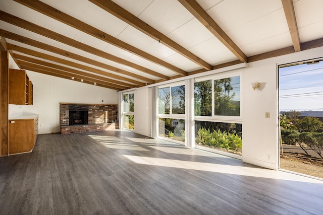 unfurnished living room with a fireplace, wood finished floors, and beam ceiling