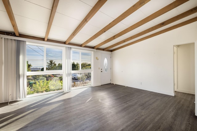 unfurnished living room featuring vaulted ceiling with beams, dark wood finished floors, and baseboards