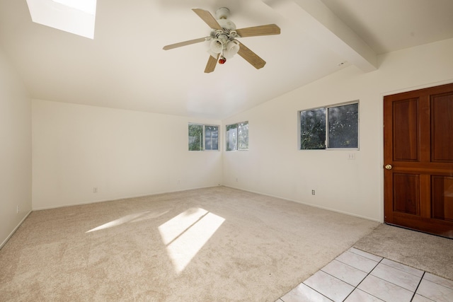 empty room with light carpet, vaulted ceiling with beams, light tile patterned floors, and a ceiling fan