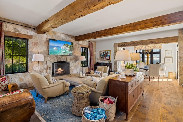 4230 Cresta Ave, Santa Barbara, CA 93110 - living room featuring beamed ceiling, a stone fireplace, a chandelier, and light wood-type flooring