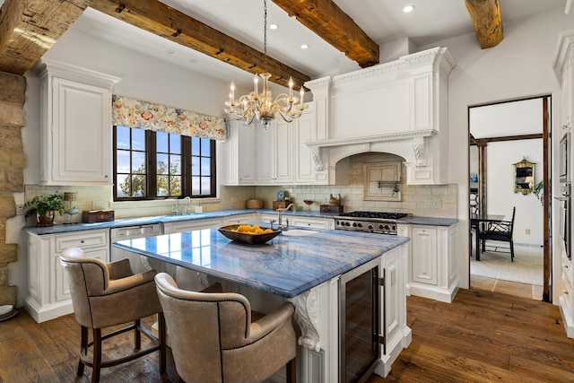 4230 Cresta Ave, Santa Barbara, CA 93110 - kitchen featuring white cabinetry, hanging light fixtures, a kitchen island with sink, decorative backsplash, and beverage cooler