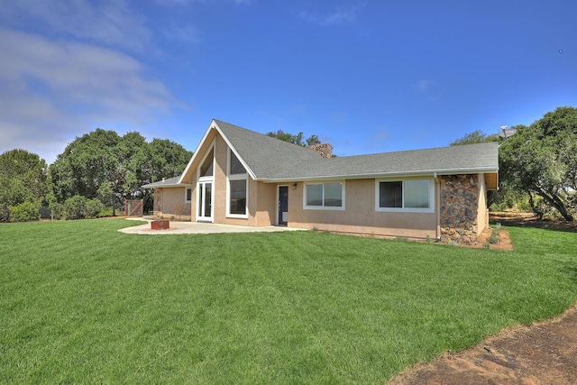 back of property with a lawn, a patio, and an outdoor fire pit