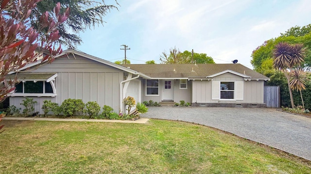 ranch-style home with a garage and a front lawn