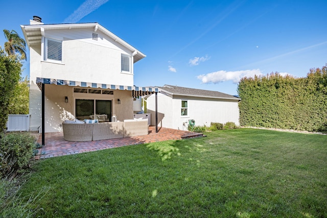 back of house with outdoor lounge area, a patio, and a lawn