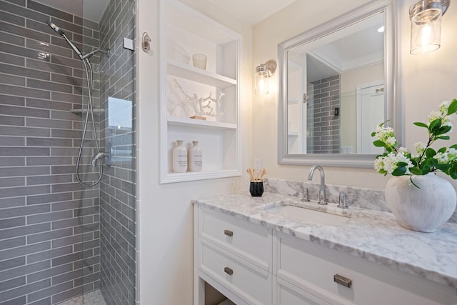 bathroom with vanity, built in features, and tiled shower