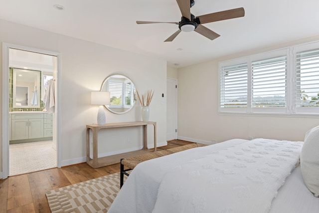 bedroom featuring connected bathroom, ceiling fan, and light hardwood / wood-style flooring