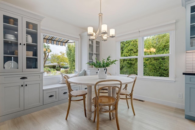 dining space with a chandelier and light hardwood / wood-style flooring