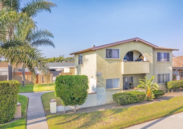 view of front of property with a balcony and a front yard