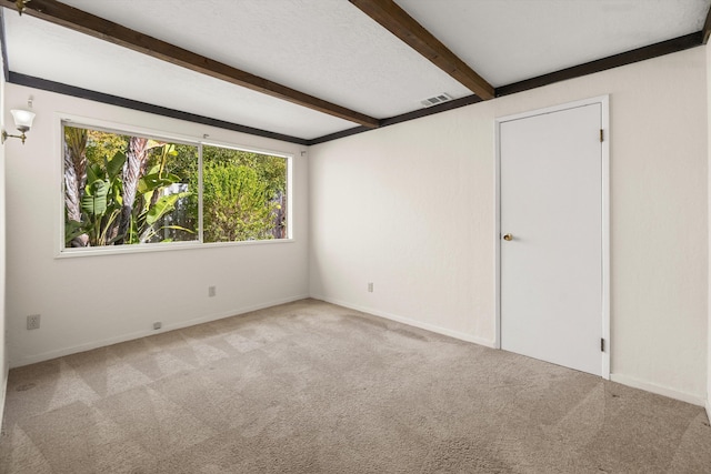 carpeted spare room with beamed ceiling and a textured ceiling