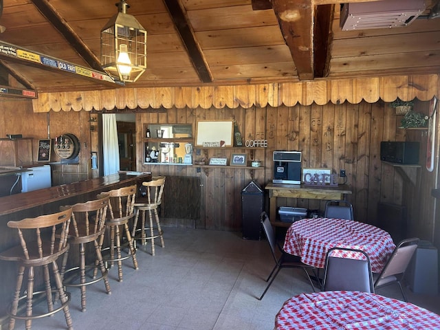 dining space featuring beamed ceiling, wooden ceiling, and wood walls