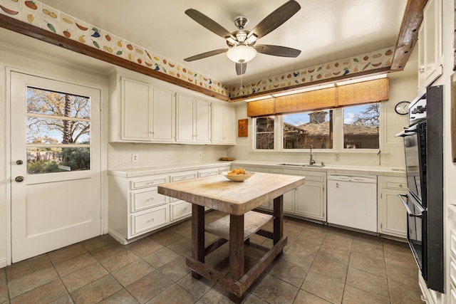 kitchen featuring sink, white cabinets, decorative backsplash, ceiling fan, and white dishwasher