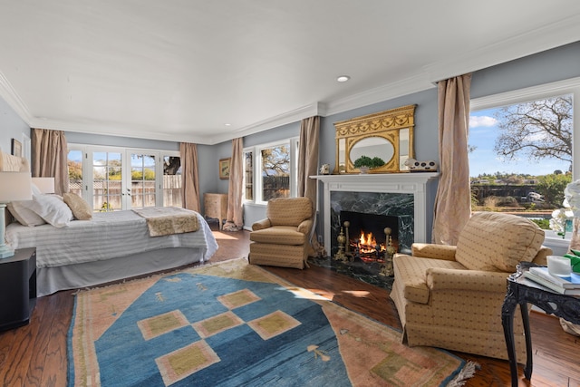 bedroom featuring french doors, dark wood-type flooring, crown molding, a high end fireplace, and access to exterior