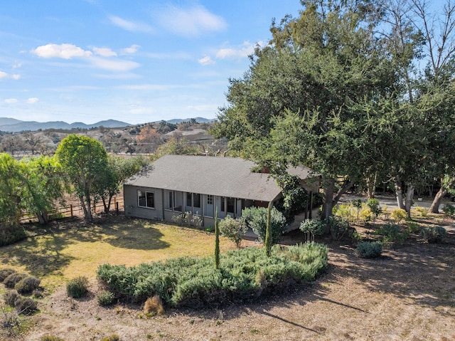 exterior space with a mountain view and a front lawn