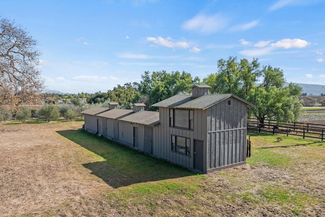 view of outdoor structure with a rural view and a lawn