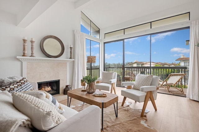 sunroom / solarium with beam ceiling and a fireplace