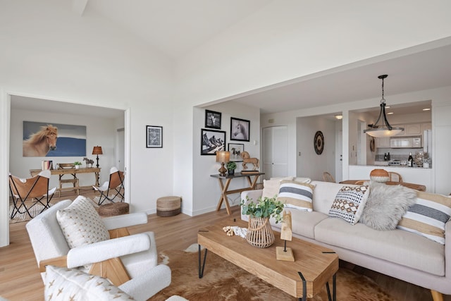 living room with high vaulted ceiling and light wood-type flooring