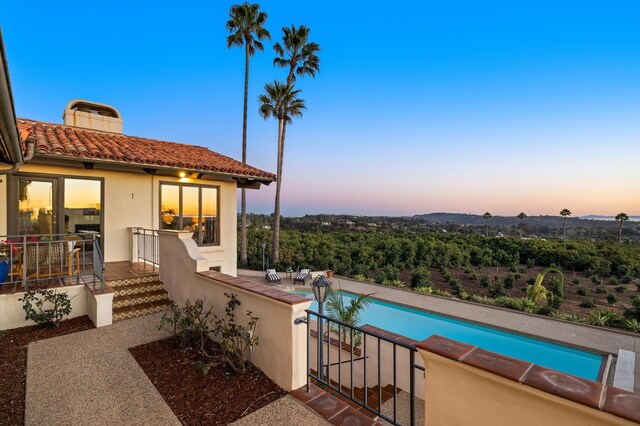 pool at dusk with a patio