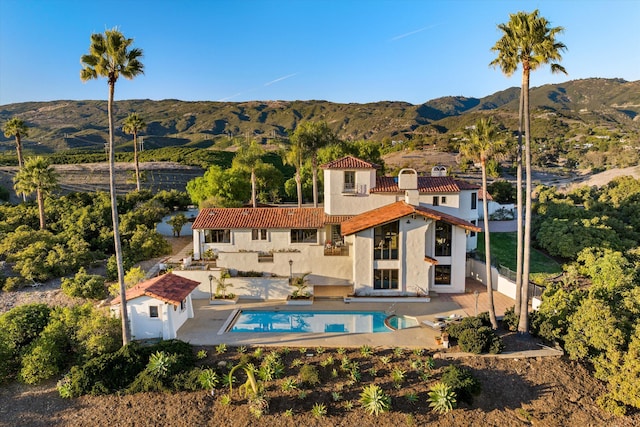 rear view of house with a mountain view and a patio