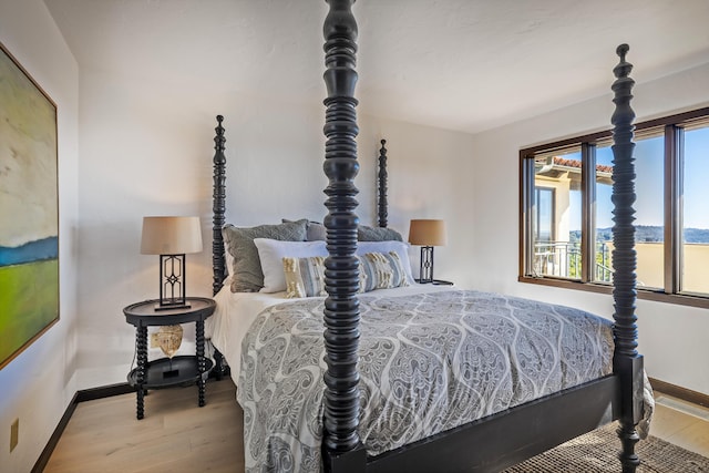 bedroom with hardwood / wood-style flooring and multiple windows