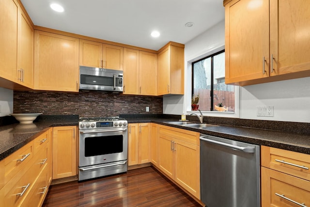 kitchen with appliances with stainless steel finishes, dark hardwood / wood-style flooring, sink, and decorative backsplash