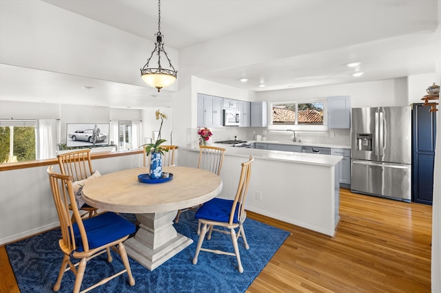 dining space with sink and light hardwood / wood-style flooring