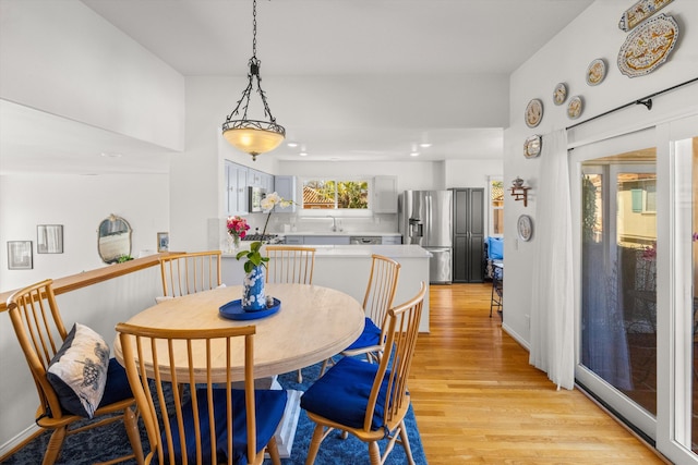 dining room featuring sink and light wood-type flooring