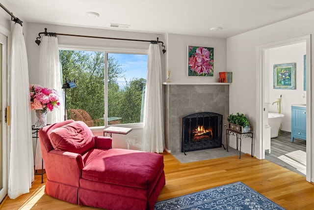 living area featuring hardwood / wood-style flooring, a wealth of natural light, and a fireplace