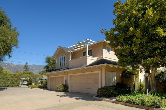 front facade featuring a garage, a balcony, and a mountain view