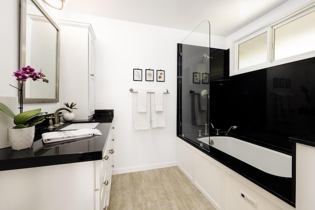 bathroom featuring enclosed tub / shower combo, vanity, and hardwood / wood-style floors