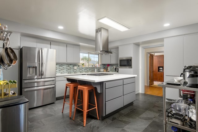 kitchen featuring island range hood, stainless steel fridge, and white cabinets