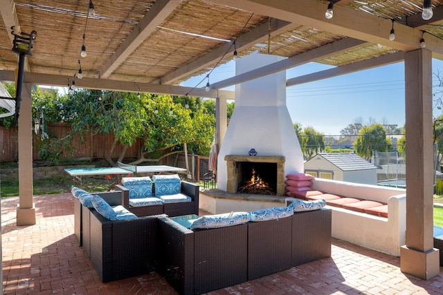 view of patio / terrace with a shed and an outdoor living space with a fireplace