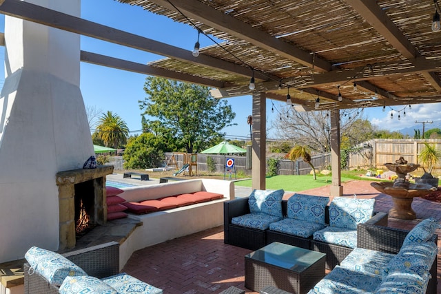 view of patio / terrace with an outdoor living space with a fireplace and a playground