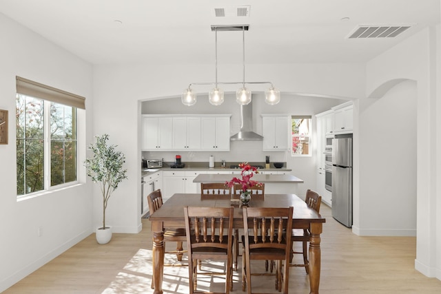 dining area featuring lofted ceiling and light hardwood / wood-style flooring