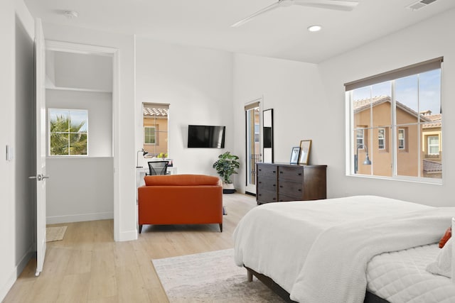 bedroom with multiple windows, light hardwood / wood-style floors, and ceiling fan