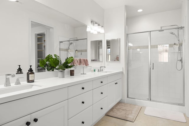 bathroom featuring tile patterned flooring, vanity, and walk in shower