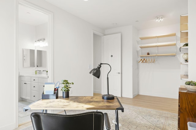 home office with sink and light hardwood / wood-style flooring