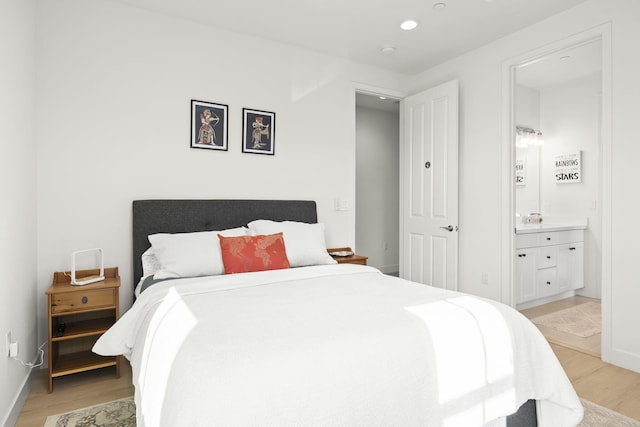 bedroom featuring ensuite bathroom and light hardwood / wood-style flooring