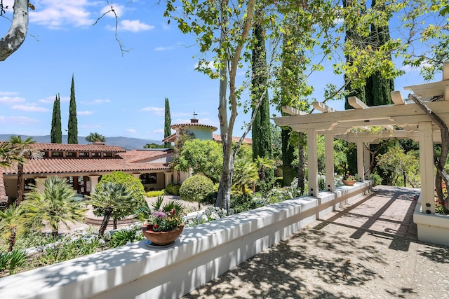 surrounding community featuring a mountain view and a pergola